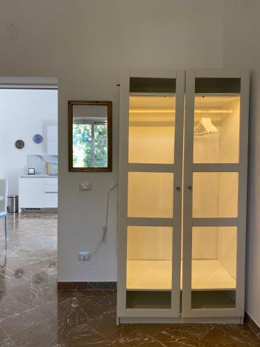 a glass cabinet in a room with a mirror at Modern apt in Taormina city center in Taormina