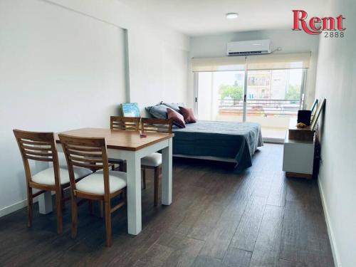 1 dormitorio con 1 cama, mesa y sillas en Rent Scalabrini y Honduras en Buenos Aires