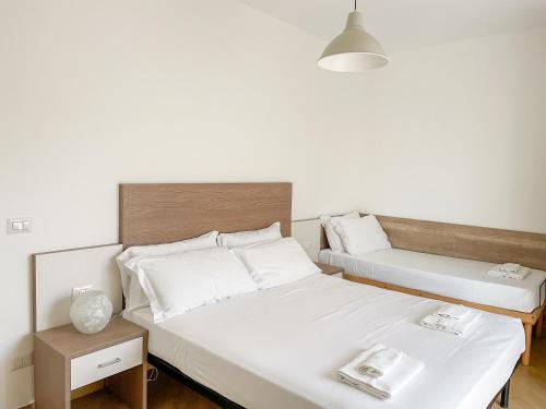 1 Schlafzimmer mit 2 Betten und einem Nachttisch in der Unterkunft Homiday - Residence K2 in Pineto