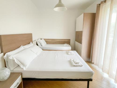 Un dormitorio con una gran cama blanca y una ventana en Homiday - Residence K2 en Pineto