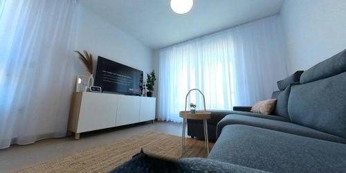 a living room with a couch and a flat screen tv at Apartamento Rokita Blanca in La Manga del Mar Menor