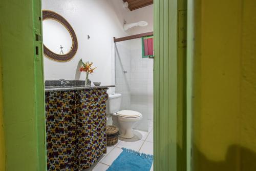 y baño con aseo, lavabo y espejo. en Pousada Canoa Nativa en Ilha de Boipeba