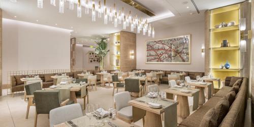a restaurant with tables and chairs and a dining room at Hyatt Regency Izmir IstinyePark in Izmir