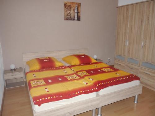 a bedroom with a bed with a yellow and red blanket at Familienurlaub auf dem Land - haustierfreundlich - 10 Minuten von Templin in Milmersdorf