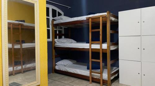 Zimmer mit Etagenbetten in einem Zimmer mit Spiegel in der Unterkunft SANTO MAR HOSTEL in Arraial do Cabo