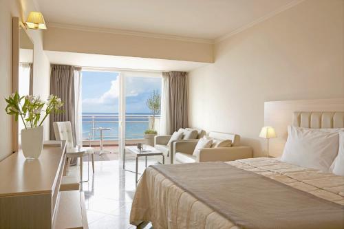 a hotel room with a bed and a view of the ocean at Pelekas Monastery in Pelekas