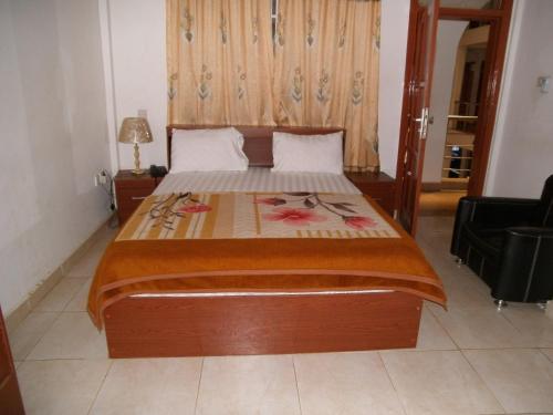a bedroom with a large bed with a wooden headboard at Pemicsa Hotel Accra in Spintex