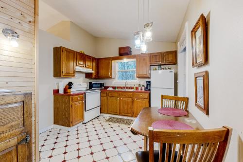 a kitchen with wooden cabinets and a table with chairs at Ozark Spring Cabins - Mountain View 01 in Eureka Springs