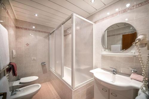 a bathroom with a shower and a sink and a toilet at Garni Hotel Max in Santa Cristina Gherdëina