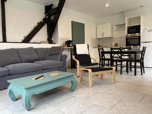 sala de estar con sofá y mesa en Aux Fines Bulles Gîte et Chambres d hôtes en Neuve-Maison