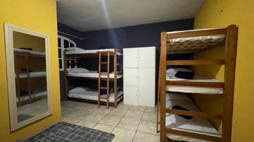 a room with three bunk beds and a mirror at SANTO MAR HOSTEL in Arraial do Cabo