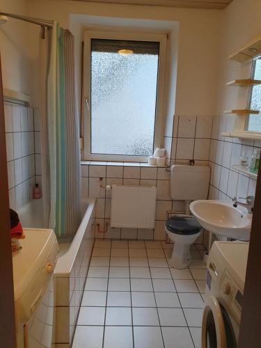 La salle de bains est pourvue d'un lavabo, de toilettes et d'une fenêtre. dans l'établissement Ferienwohnung Linden 87, à Willich
