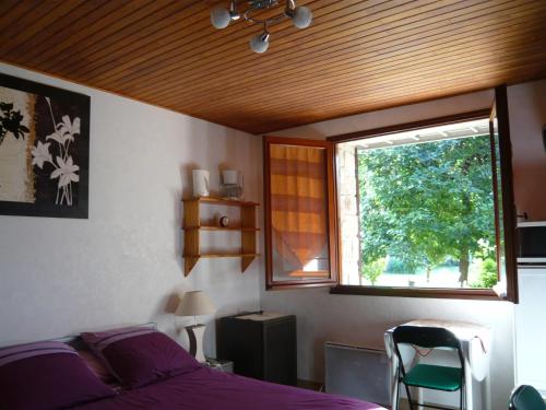 ein Schlafzimmer mit einem lila Bett und einem Fenster in der Unterkunft MARC in Saint-Paul-Trois-Châteaux