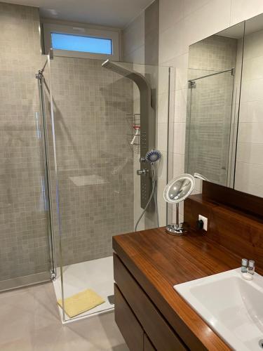 a bathroom with a glass shower and a sink at Die Bäckerei in Maria Rain