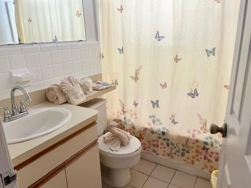 a bathroom with a toilet and a shower curtain with butterflies at Sea Club I in Longboat Key