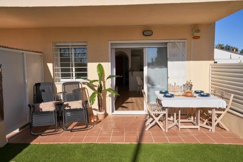 een patio met een tafel en stoelen op een huis bij Rincón en la playa by Rinconesmediterraneos in L'Eucaliptus