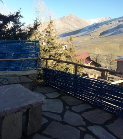 a patio with a fence and a view of a mountain at Gite Oukaimeden in Oukkainrdem
