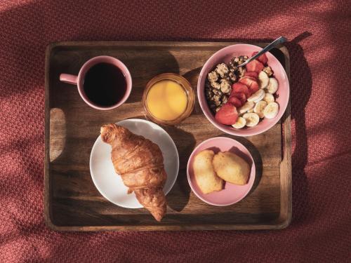 a tray of breakfast foods and a cup of coffee at Seven Hotel Paris in Paris