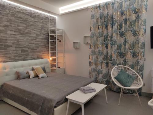 a bedroom with a large bed and a chair at Alice's Studio in Santa Marinella
