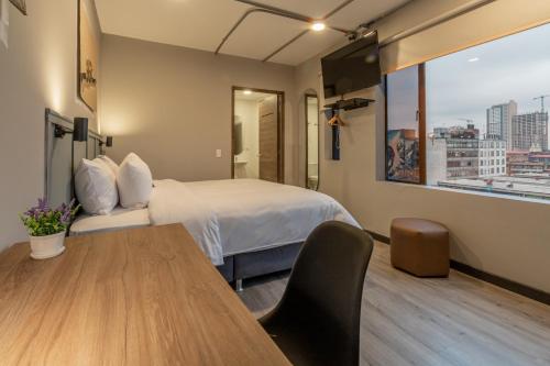 a hotel room with a bed and a table at Bon 17 Hotel By SHG in Bogotá