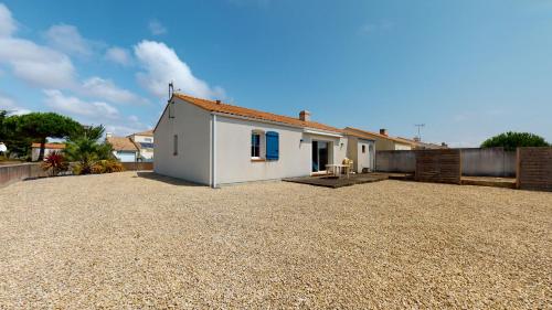 une petite maison blanche avec une allée en gravier dans l'établissement Villa La Grande Vallée, à Saint-Gilles-Croix-de-Vie