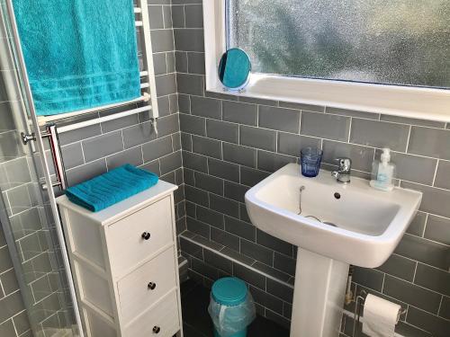 baño pequeño con lavabo y ventana en Wight Waves Holidays en Sandown