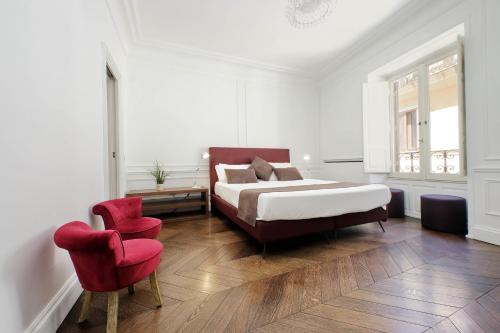 a bedroom with a bed and a red chair at Youroom Carrozze in Rome