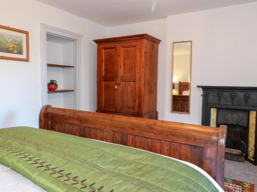 a bedroom with a wooden bed and a wooden cabinet at Mill View Duplex in Mansfield