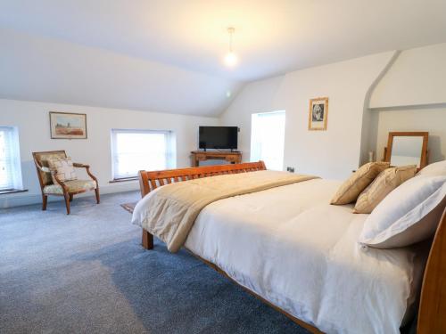 a bedroom with a large bed and a chair at Mill View Duplex in Mansfield