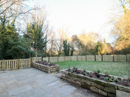 a backyard with a fence and some plants at Mill View Duplex in Mansfield