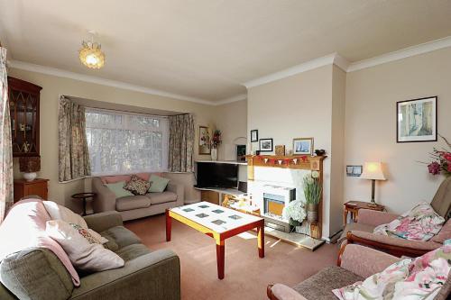 a living room with two couches and a tv at Whitestones in Brighstone