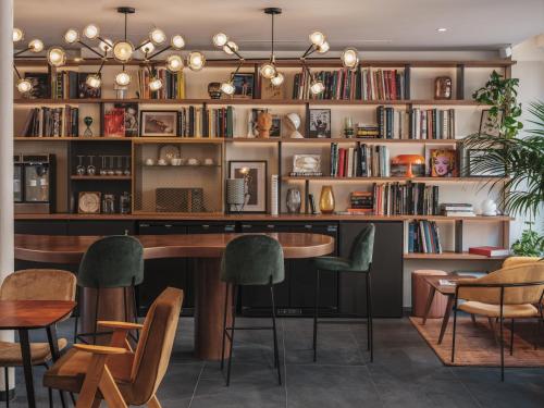 biblioteca con mesa, sillas y estanterías en Seven Hotel, en París