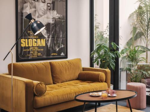 a living room with a yellow couch and a table at Seven Hotel Paris in Paris