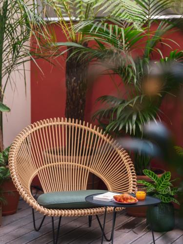 a rattan chair and a table with food on it at Seven Hotel Paris in Paris