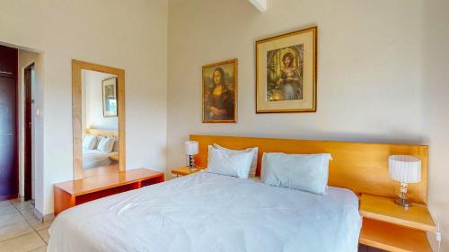 a bedroom with a white bed and a mirror at San Lameer 3123 by Top Destinations Rentals in Southbroom