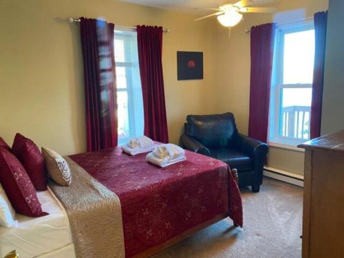 a bedroom with a bed and a chair in a room at Moon Swept on Keuka in Hammondsport