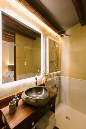 a bathroom with a stone sink and a mirror at La Caseta del Munt in Castelltersol