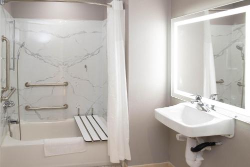 La salle de bains blanche est pourvue d'un lavabo et d'une douche. dans l'établissement Motel 6 Highland CA San Bernardino East, à Highland