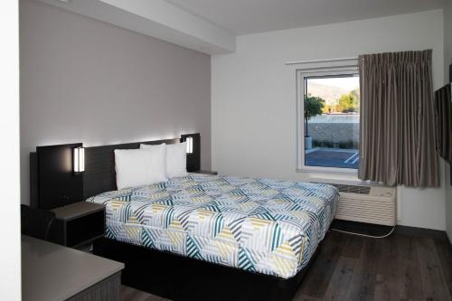 une chambre d'hôtel avec un lit et une fenêtre dans l'établissement Motel 6 Highland CA San Bernardino East, à Highland