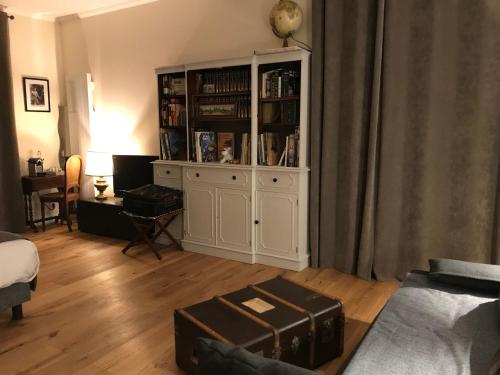 a living room with a large white cabinet with books at L ESCALE EN BEAUCE in Maisons