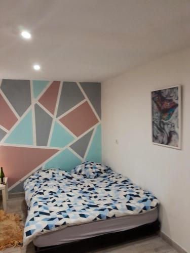 - une chambre dotée d'un lit avec un mur géométrique dans l'établissement Maison confortable à Loches + Jardin spacieux, à Loches