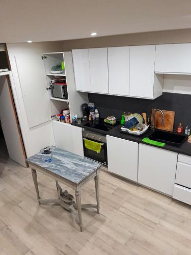 une cuisine avec des armoires blanches et une table à l'intérieur dans l'établissement Maison confortable à Loches + Jardin spacieux, à Loches