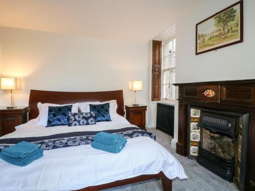 a bedroom with a bed with two blue pillows on it at Cotton Mill Cottage in Mansfield