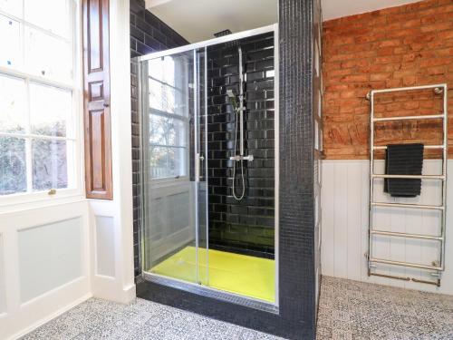 a shower with a glass door in a bathroom at Cotton Mill Cottage in Mansfield