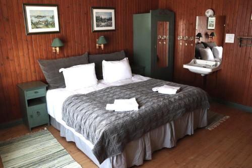 a bedroom with a bed with two towels on it at Bygdin Høyfjellshotell in Beitostøl