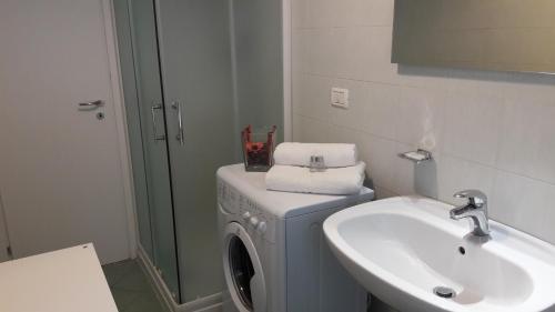 een badkamer met een wasmachine en een wastafel bij Bolognamania Apartments-Smart in Bologna