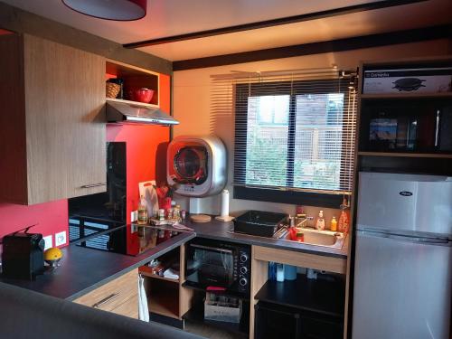 une petite cuisine avec un réfrigérateur et un évier dans l'établissement Bruse & Costa à la montagne, à Chorges