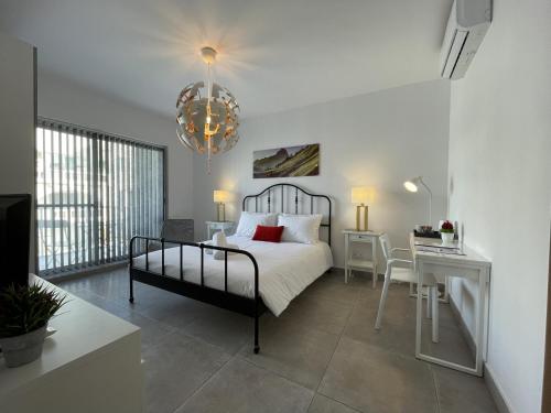 a bedroom with a bed and a table and a desk at Casa Leon Malta in St Julian's