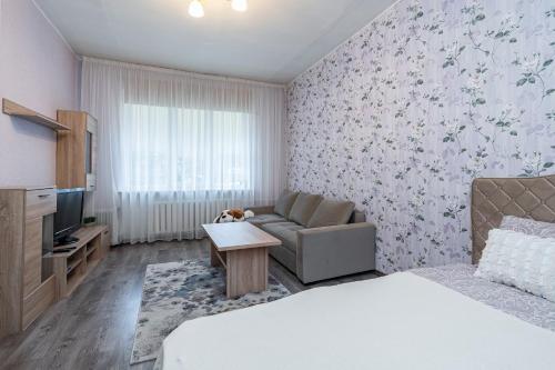 a living room with a bed and a couch and a tv at Pae 52 Apartment, Free Parking ,Airport 2km in Tallinn