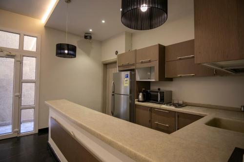 a kitchen with wooden cabinets and a stainless steel refrigerator at Arayik Resort in Taif